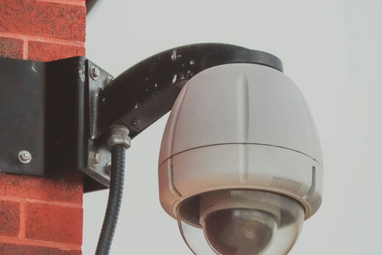 a-security-camera-attached-to-a-brick-wall.jpg a security camera attached to a brick wall